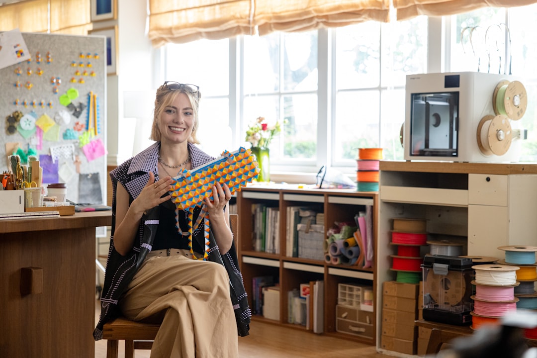 Woman holding colorful beaded necklace in workshop